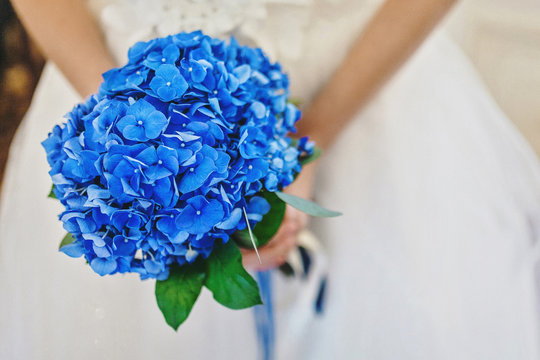 Blue wedding bouquet in the hands of the bride