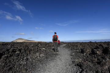 Hiking with children in the volcanic lunar landscape of the  Timanfaya National Park, Lanzarote, Canary Islands, Spain, Europe
