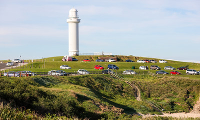 Fototapeta na wymiar Wollongong Head Flagstaff Lighthouse, with vehicles facing south towards Pacific Ocean