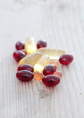 Pile of capsules Omega 3 on wood background. Close up,