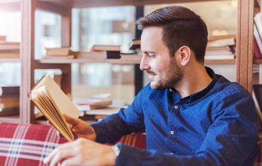 Young student reading a book, preparing for the seminar. Education, knowledge, relaxation concept