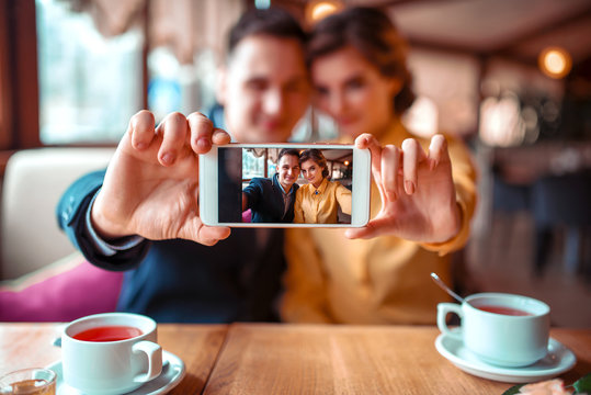 Love couple makes selfie on camera in restaurant