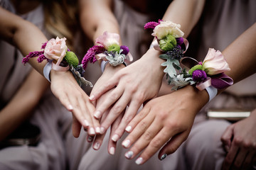 Hands of bridesmaids with buttonholes