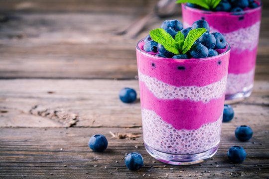 Blueberry smoothies with chia pudding in glasses with fresh berries and mint