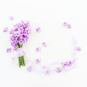 Gentle bouquet of pink hyacinth flowers, paper cards and tapes on white background. Flat lay, top view.