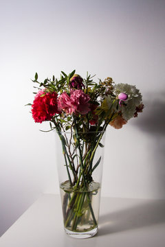 Slightly wilted flowers in a transparent vase