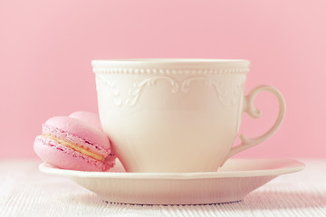 pink macaron homemade and a cup of coffee on pink background toned