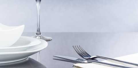 Messer und Gabel, Teller und Glas auf spiegelndem Tisch, Panorama, Hintergrund