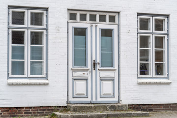 Fototapeta na wymiar Alte Haustür mit Fenstern in einer Fassade