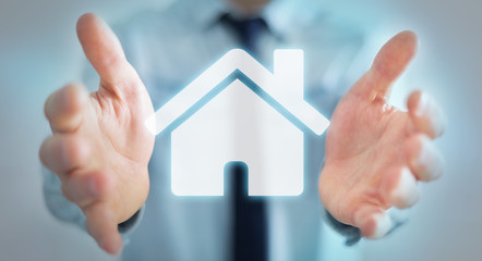 Businessman holding 3D rendering icon house in his hand