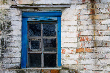 Fototapeta na wymiar Blue wooden window in old brick wall