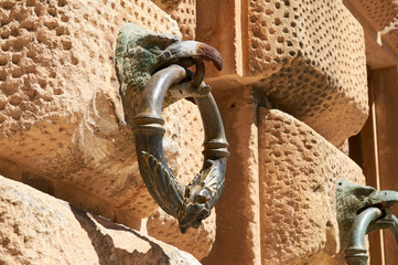 Eagle with metal ring in beak, Architectural detail of the walls, Alhambra de Granada, Spain.