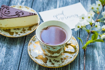 Still life with cup of tea and cake on the wooden background