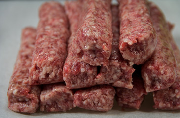 Raw kebab minced meat on white paper for grilling