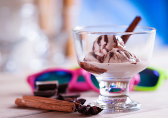 Ice cream sundae, spices, chocolate pieces and sun glasses 