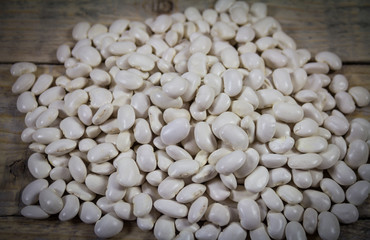 Raw white beans beans on a wooden background