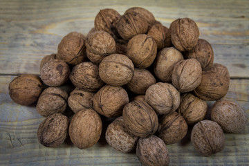 Group walnuts in shell on a wooden background