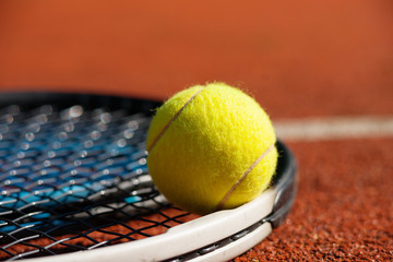 Tennis racket and ball on court 