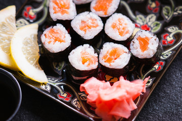 Sushi rolls with salmon, ginger and lemon slice 
