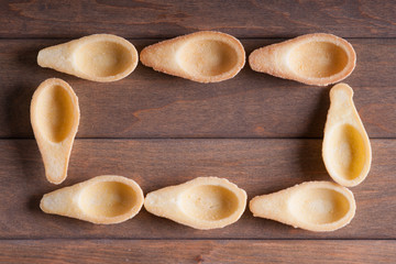 Frame made from empty tartlets on a wooden background 