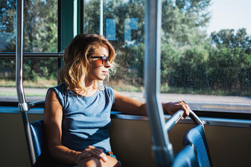 Young woman riding a public bus on a sunny day