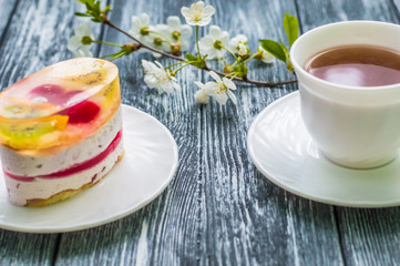 Still life with cup of tea and cake on the wooden background