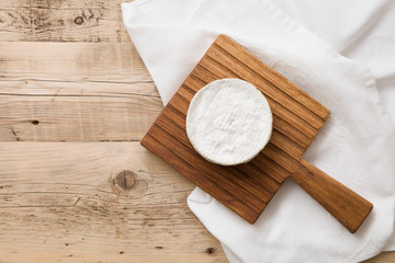 Fototapeta na wymiar Top view on Camembert cheese on wooden board. Serving French homemade soft cheese. Food concept