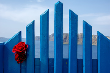 A traditional symmetric door yard with a pair of red roses, Santorini. Honeymoon summer aegean cycladic background.