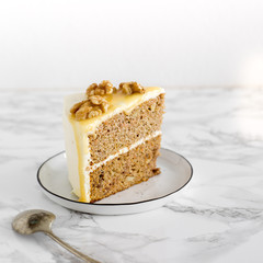 piece of wedding or Birthday sugar free and gluten free Cake with salty caramel and nuts on marble background. Vegan food concept
