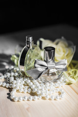 Obraz na płótnie Canvas Two bottles of female perfume and pearls 2