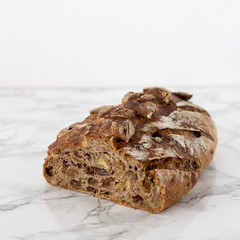 Fresh home made bread with nuts and dry fruits on marble background