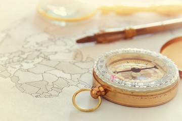 Image of map, magnifying glass and old compass. selective focus