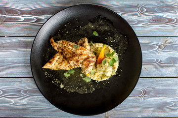 Gourmet plate with chicken and rice isolated on wooden background.