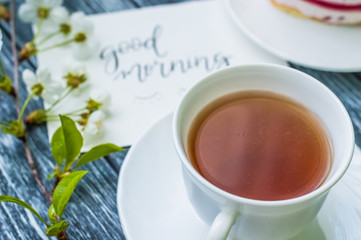 Still life with cup of tea and cake on the wooden background