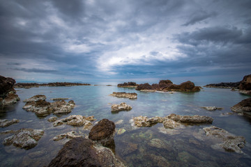 Long exposure at sunset with calm sea and rocks, Crete, Greece.