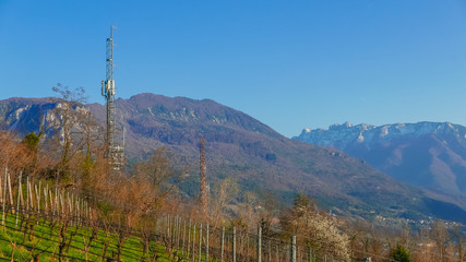 Two communication towers against city in the mountain valley