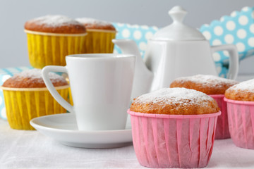 Lemon and coconut cakes on plate and cup of tea