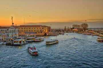 Fototapeta premium Venetian city landscape at sunset. Moored boats along the canal shore.