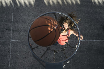 Naklejka premium Young woman playing in basketball