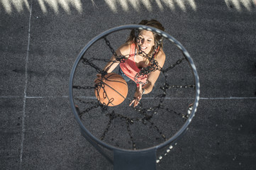 Naklejka premium Young woman playing in basketball