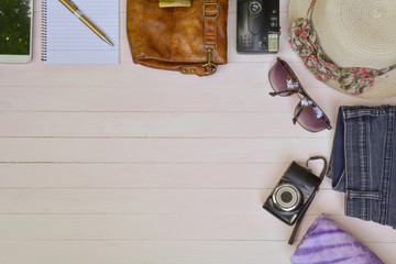 Camera and supplies wooden table background. Top view with copy space.