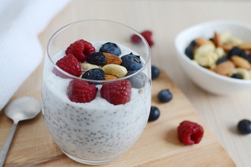 Vitamin breakfast yogurt chia seed cocktail with berries, dried fruits and nuts in glass