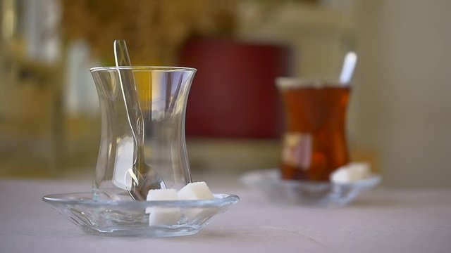 Slow Motion serving Turkish tea with sugar cubes and a teaspoon. Turkish Tea served from traditional 2 tiered teapot. (Bottom one for boiling water and top pot for brewed tea). High Quality Camera Ori