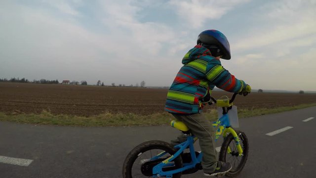 Cute little boy riding a bike.	
Boy riding a bike along the cycle path. Stabilized video.