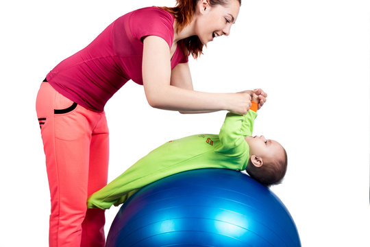 A mother and baby doing gymnastic exercises on the ball. Isolated background