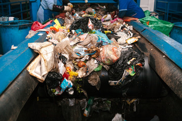 Workers sorted out the waste received by the modern plant for sorting and recycling waste. Waste processing plant. Technological process. Recycling and storage of waste for further disposal.