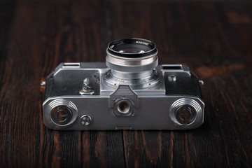 Fototapeta na wymiar The old rangefinder camera on a wooden background.