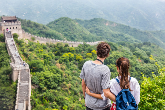 Happy couple enjoying view of Great wall of china landscape near Beijing city. Asia travel. Tourists relaxing together in summer.