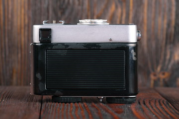 Fototapeta premium The old rangefinder camera on a wooden background.