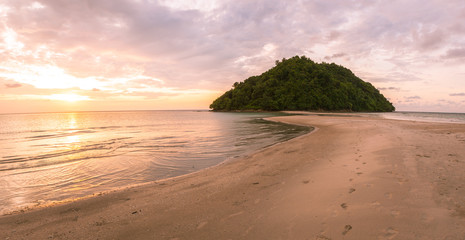 Tropical island and paradise beach at sunset